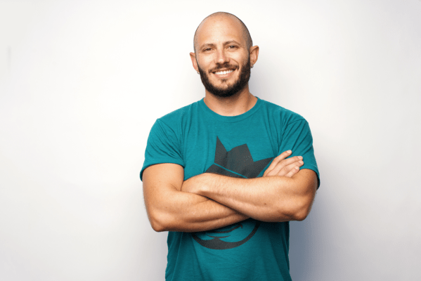 Noah Kagen in a green t-shirt, with folded arms and smiling.